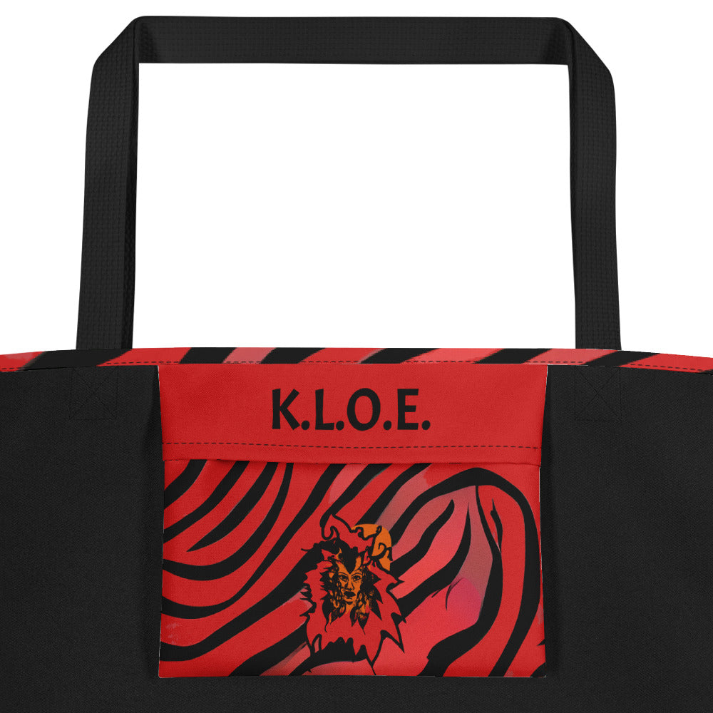 The inside pocket of a large red and black tote bag from Kloe Store featuring a bold artistic face design and abstract swirling patterns, with black straps, perfect for trendy and functional everyday use, detail view.