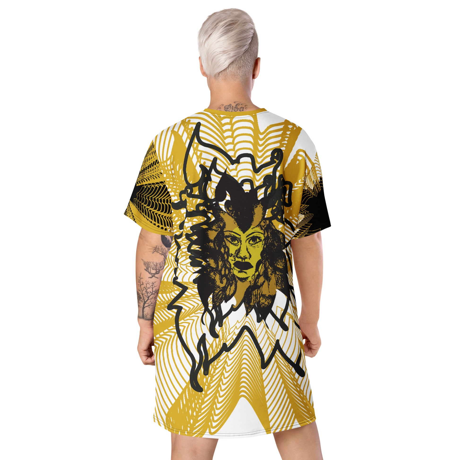 Back view of an all-over print K.L.O.E. t-shirt dress featuring a striking gold and white geometric radiating pattern, with a central hand-drawn black and gold and yellow face design, celebrating modern bohemian style and self-expression, worn by a model.