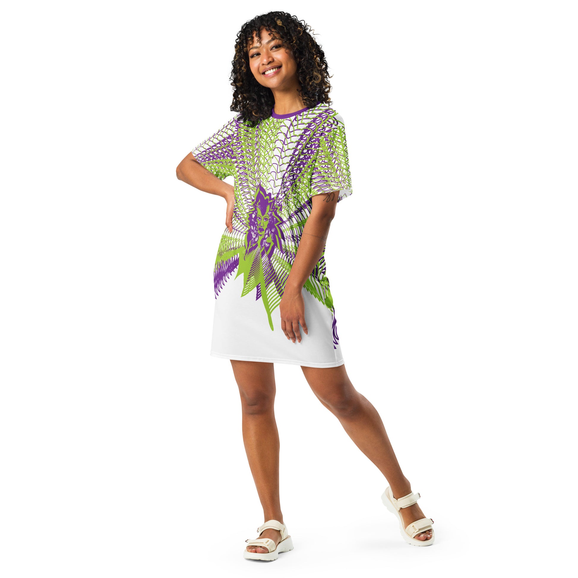 Front view of an all-over print K.L.O.E. t-shirt dress featuring vibrant purple and green geometric patterns radiating from a central hand-drawn face design, embodying individuality, self-expression, and modern bohemian fashion, worn by a model.