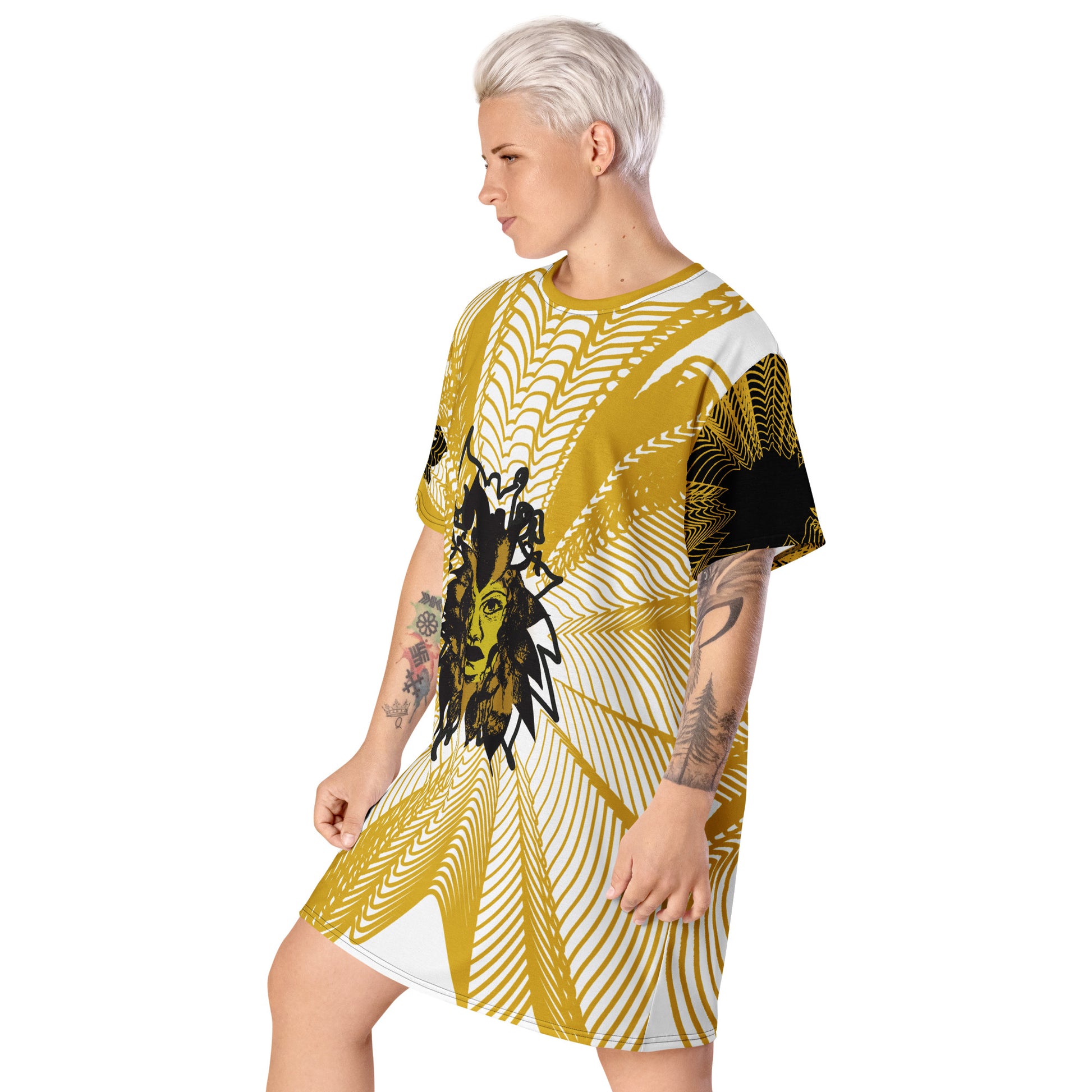 Side view of an all-over print K.L.O.E. t-shirt dress featuring a bold gold and white geometric pattern radiating from a central hand-drawn black and gold and yellow face design, embodying individuality, modern bohemian style, and self-expression, worn by a model.