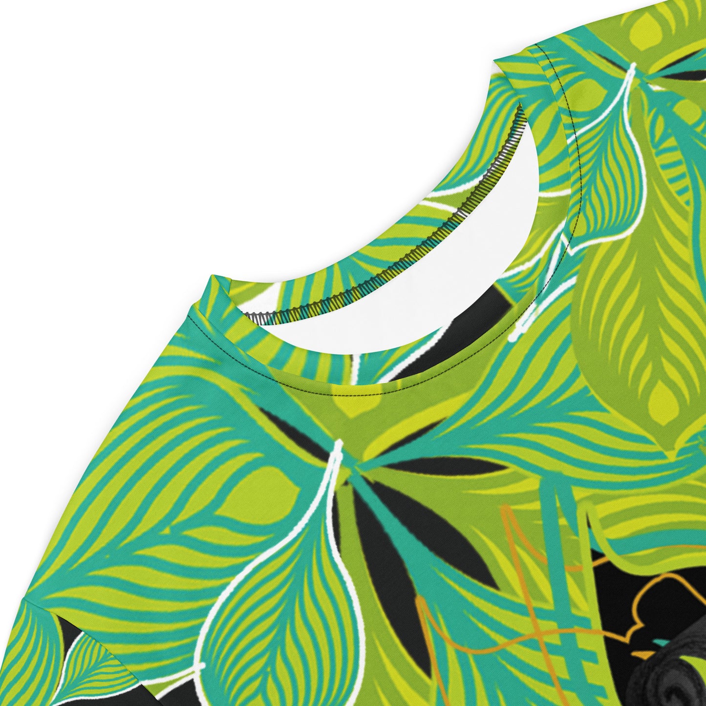 Detail view of an all-over print K.L.O.E. t-shirt dress featuring vibrant green and yellow leaf patterns framing a detailed black and gray hand-drawn face design, celebrating individuality, modern bohemian style, and self-expression, worn by a model.