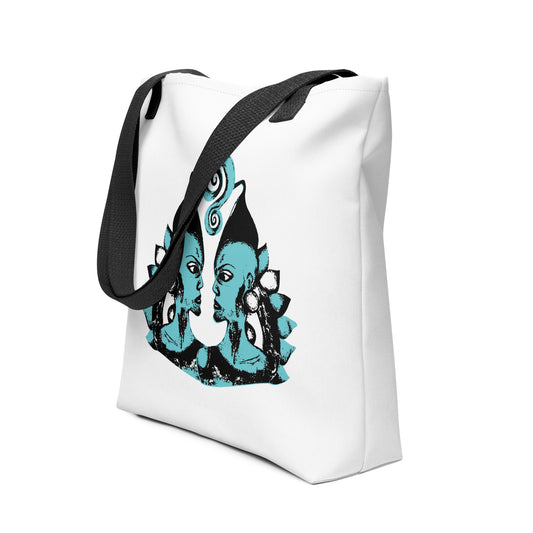 White tote bag with a bold K.L.O.E. hand-drawn design featuring two mirrored faces in black and teal, highlighting cultural inspiration, individuality, and modern bohemian self-expression.