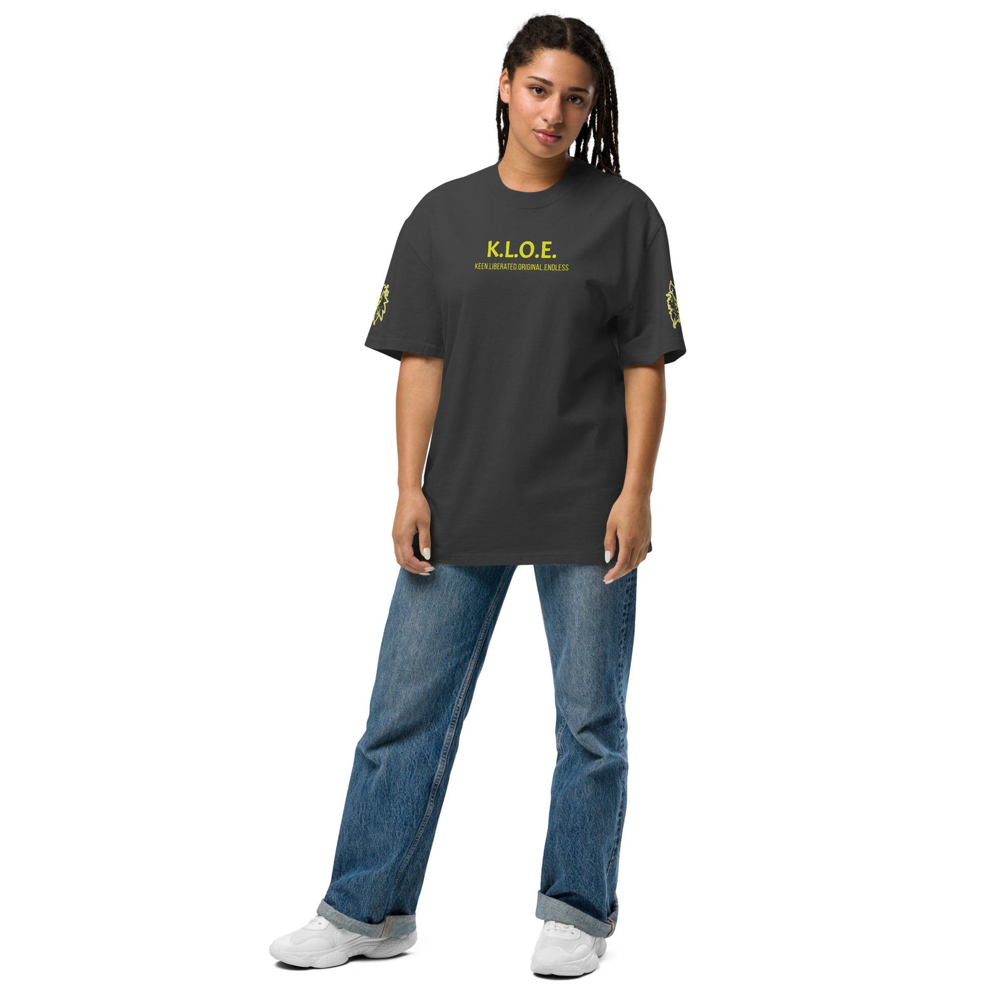 Black unisex oversized t-shirt with a bold yellow hand-drawn face graphic on the back, embodying culturally inspired fashion and modern boho style. The front features the K.L.O.E. logo and ‘KEEN, LIBERATED, ORIGINAL, ENDLESS’ text, celebrating individuality and expressive fashion for a contemporary, liberated lifestyle.