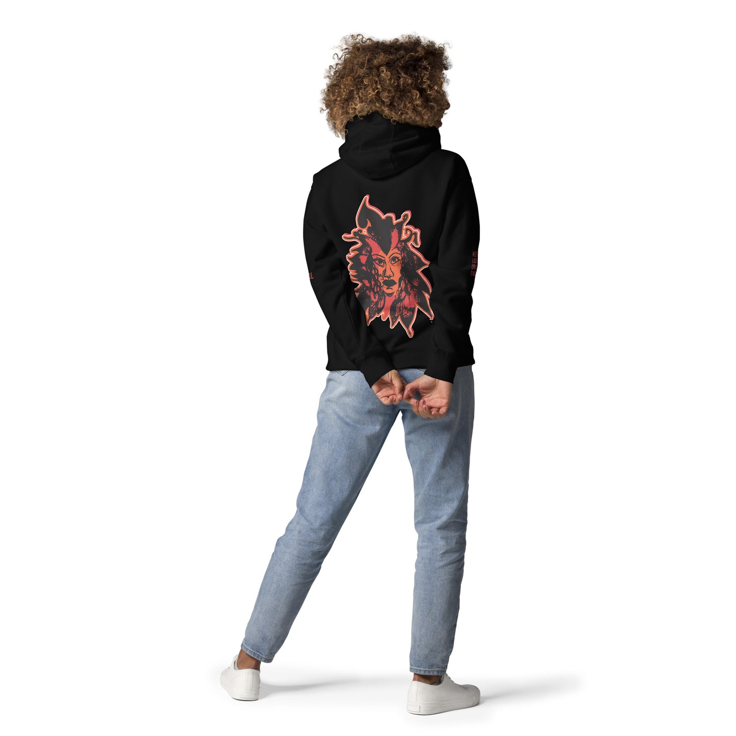 Black unisex hoodie featuring a striking red, hand-drawn face graphic on the back and front, inspired by global artistry and expressive fashion. The sleeve showcases ‘KEEN, LIBERATED, ORIGINAL, ENDLESS,’ embodying modern boho style and empowering individuality. A statement piece for those embracing contemporary, culturally inspired fashion.