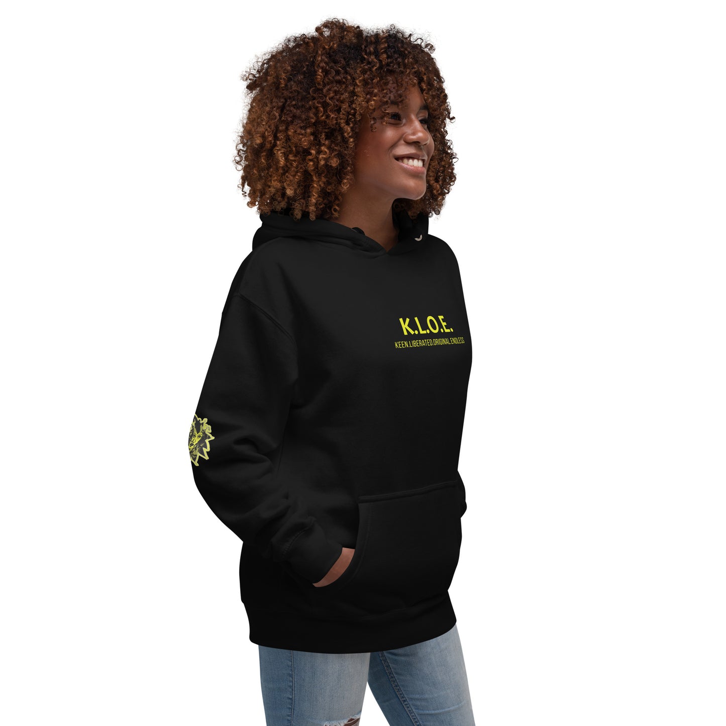 Black unisex hoodie with a bold yellow hand-drawn face graphic on the back, embodying culturally inspired fashion and modern boho style. The front features the K.L.O.E. logo and ‘KEEN, LIBERATED, ORIGINAL, ENDLESS’ text, celebrating individuality and expressive fashion for a contemporary, liberated lifestyle.