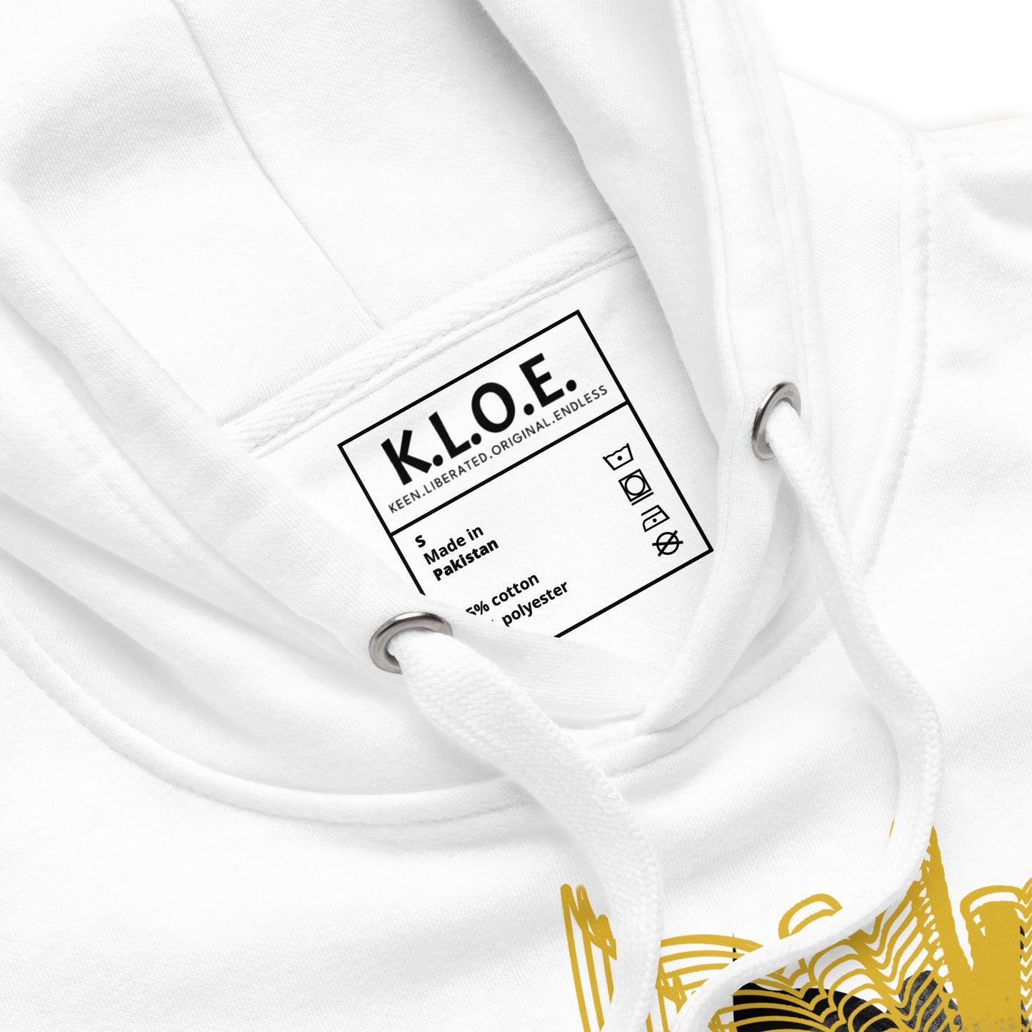 Detail view of a front side of a white K.L.O.E. hoodie featuring a striking hand-drawn face design surrounded by radiant golden abstract patterns—an artistic and empowering piece of handcrafted fashion, blending bohemian style clothing with contemporary fashion for bold self-expression and individuality.