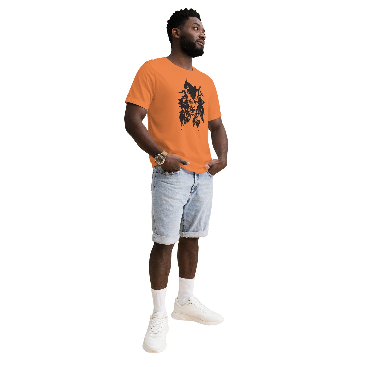 The model wearing orange K.L.O.E. T-shirt featuring a culturally inspired, hand-drawn black graphic of a bold, expressive face surrounded by intricate details, celebrating individuality and artistic self-expression in modern bohemian style fashion.